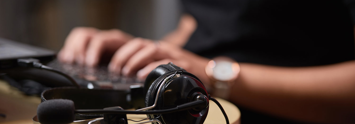 Casque de transcription audio au premier plan et frappe au clavier, secrétariat à distance Assistance Virtuelle