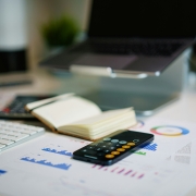 cout-secretaire-salariee-vs-externalisee-calcul.jpg Calculatrice et graphiques financiers sur un bureau — comparatif coût secrétaire salariée vs externalisée
