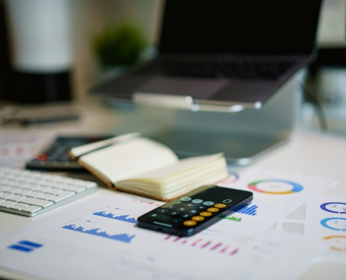 Calculatrice et graphiques financiers sur un bureau — comparatif coût secrétaire salariée vs externalisée