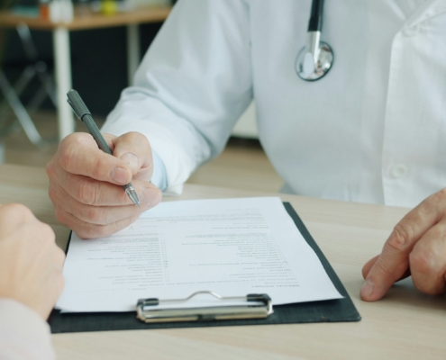 Médecin dictant un compte rendu médical pour frappe sous dictée par une secrétaire médicale à distance