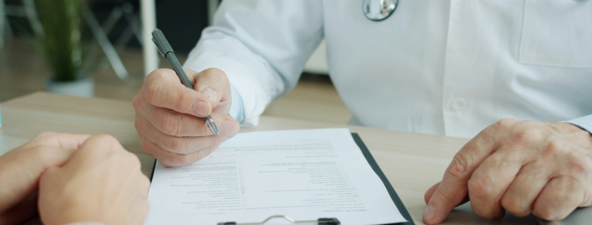 Médecin dictant un compte rendu médical pour frappe sous dictée par une secrétaire médicale à distance