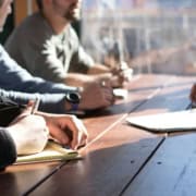 Retranscription de réunion : les erreurs à éviter Personnes en réunion professionnelle prenant des notes pour retranscription