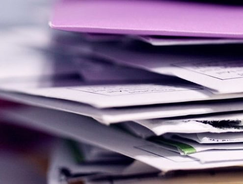 Pile de dossiers et documents illustrant la gestion confidentielle des données dans le secrétariat externalisé