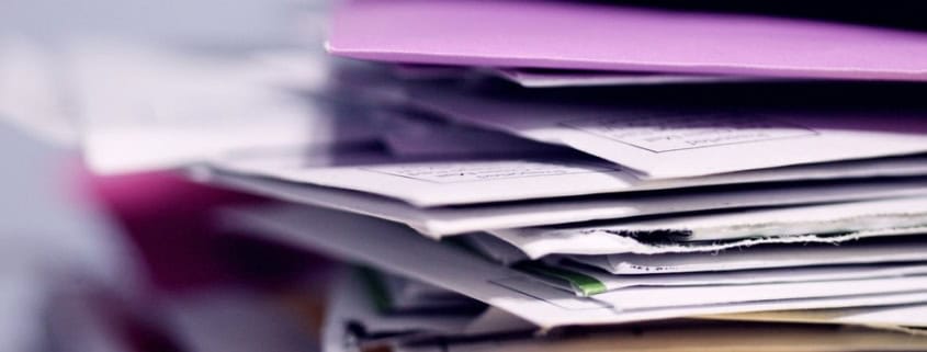Pile de dossiers et documents illustrant la gestion confidentielle des données dans le secrétariat externalisé