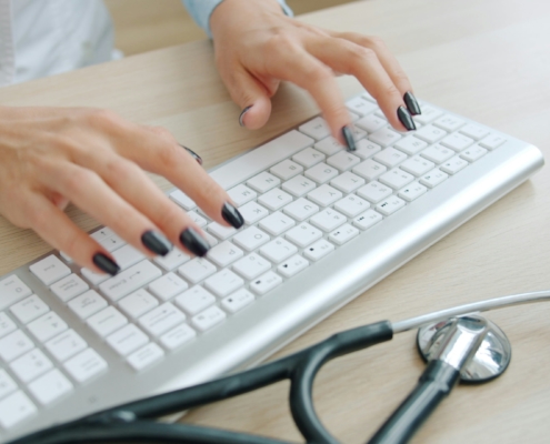 Professionnel de santé rédigeant un compte-rendu médical, illustrant les limites de la transcription par IA