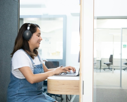 Secrétaire virtuelle concentrée, casque audio, relisant un document de transcription sur son écran d'ordinateur