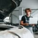 Expert automobile inspectant un véhicule endommagé chez un réparateur